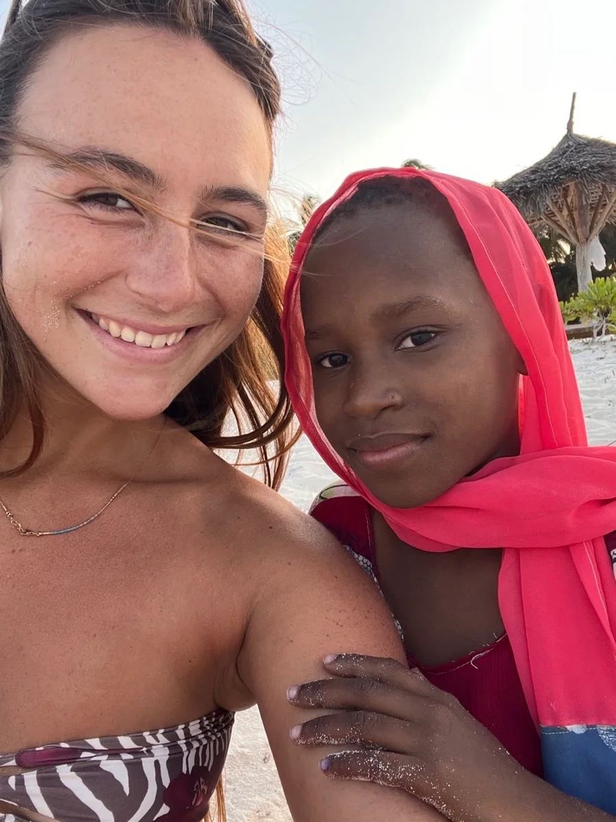 A traveler and a young local friend smiling together in Zanzibar